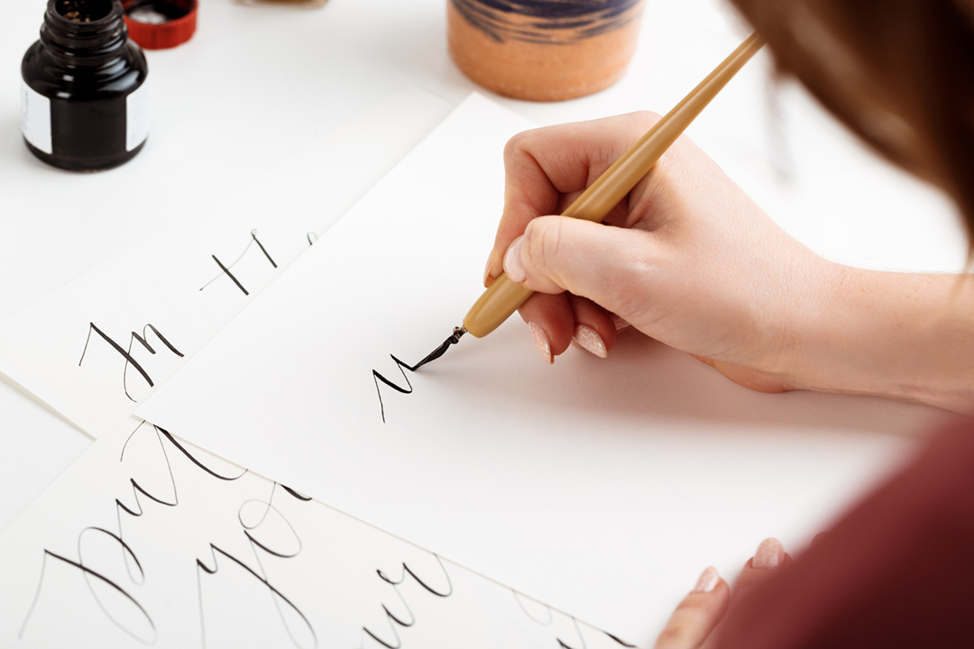 Person practicing calligraphy with ink pen
